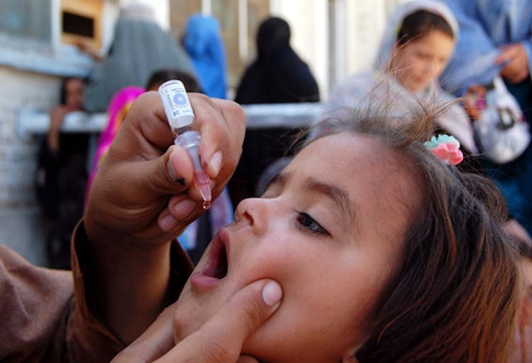 Child being administered polio vaccination.